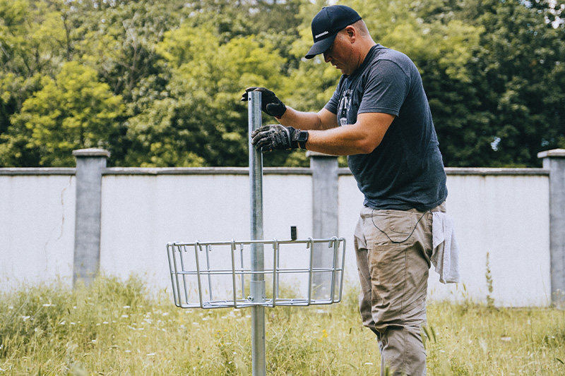 Disc golf basket being installed