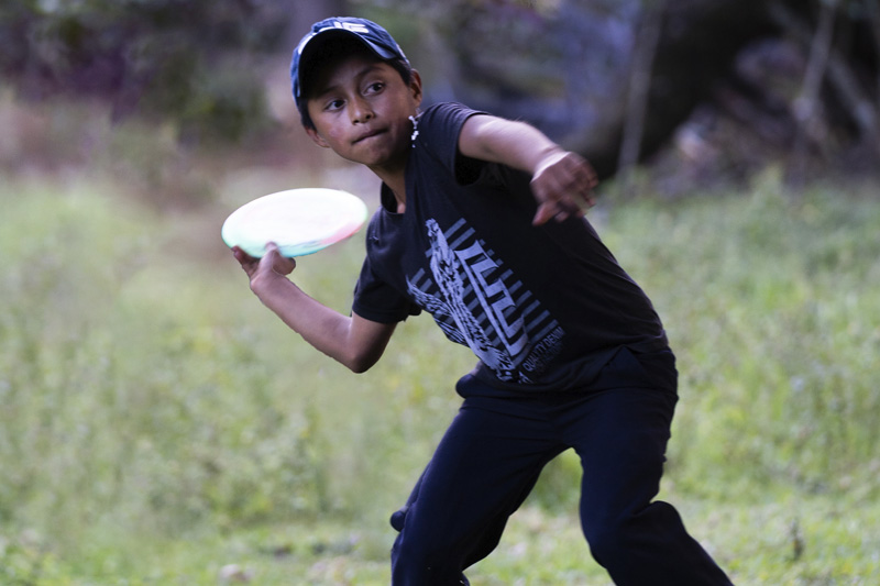 Young boy playing disc golf